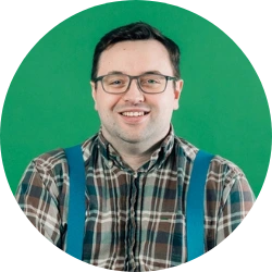 man with glasses against a green background wearing a shirt and brace