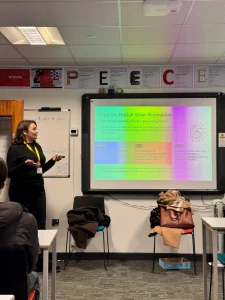 Senior Project Manager at BSR stood in front of a classroom with a slide on what BSR do beside her